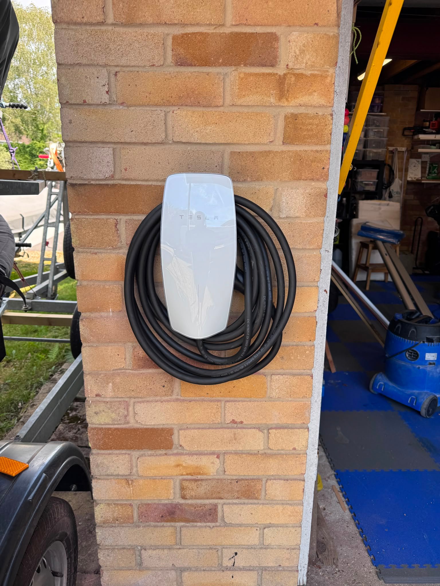 New Tesla EV charger installed on an external brick wall